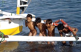 Ampenan: Ein Fischerboot wir an Land getragen, auch Kinder helfen mit