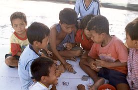 Kartenspielende Kinder im Fischerdorf Ampenan