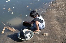 Bugis-Dorf bei Labuhan Lombok: Geschirrsplen im schmutzigen Wasser