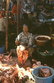 Frau mit Kuhkopf und anderem Fleisch auf dem Markt in Kediri