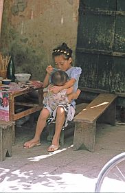 Hanoi: Mdchen fttert Geschwisterchen